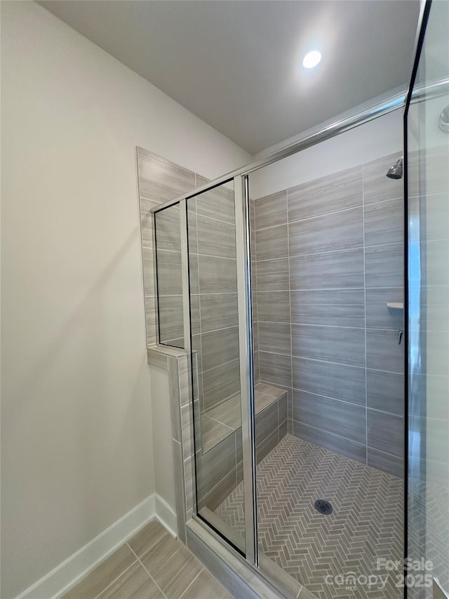 bathroom with a shower stall, tile patterned flooring, baseboards, and recessed lighting