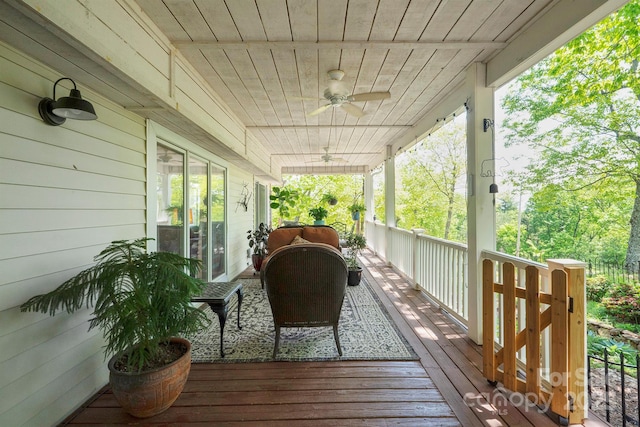 wooden terrace featuring a porch and a ceiling fan