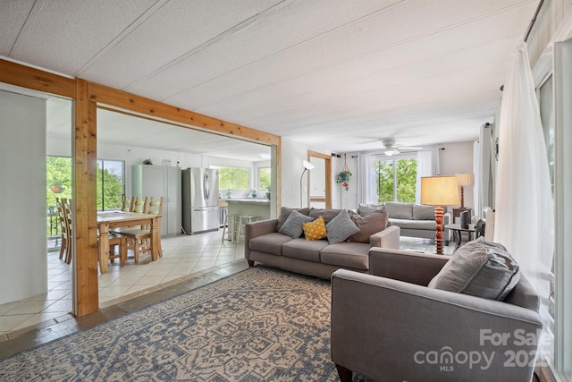 living area with tile patterned floors and ceiling fan
