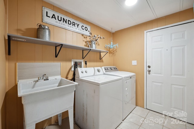 washroom featuring laundry area, a sink, light tile patterned flooring, and washer and dryer