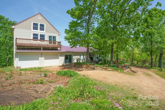 view of front of property with a garage, driveway, and metal roof
