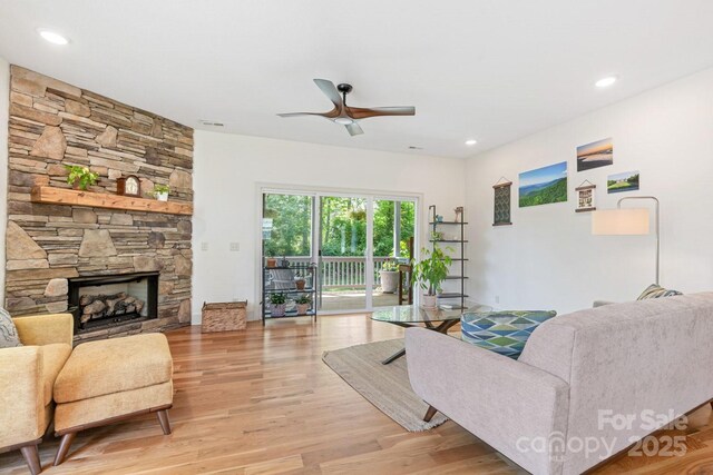living area featuring recessed lighting, a ceiling fan, light wood finished floors, and a fireplace
