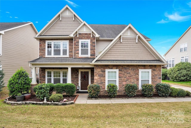 282 Fischer Rd, Fort Mill, SC 29175 - craftsman house featuring stone siding, a front lawn, and roof with shingles