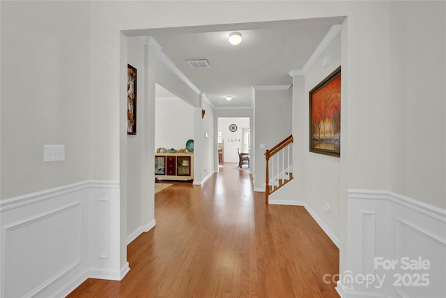 282 Fischer Rd, Fort Mill, SC 29175 - hallway featuring wood finished floors, crown molding, a wainscoted wall, stairway, and a decorative wall