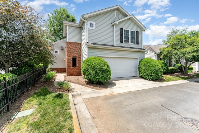 traditional-style home with brick siding, driveway, fence, and a garage