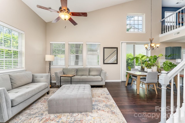 living room with dark wood-style floors, ceiling fan with notable chandelier, high vaulted ceiling, and visible vents