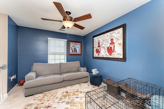 carpeted living room featuring a textured ceiling, visible vents, baseboards, and ceiling fan