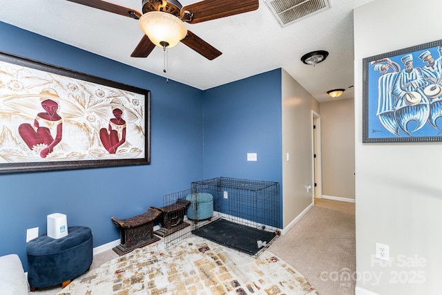 interior space featuring carpet flooring, baseboards, a ceiling fan, and visible vents