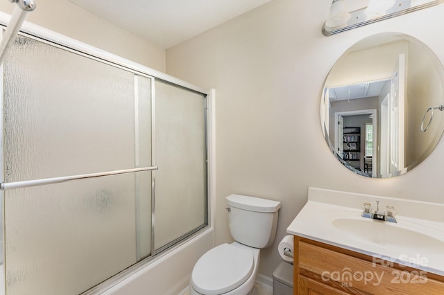 bathroom with vanity, toilet, and bath / shower combo with glass door