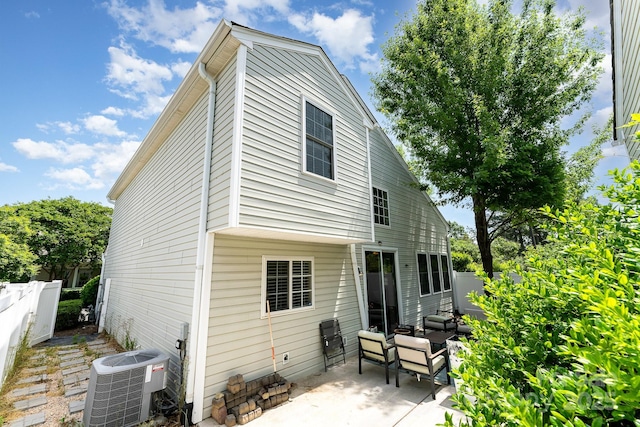 rear view of property with central AC unit, fence, a patio, and an outdoor hangout area