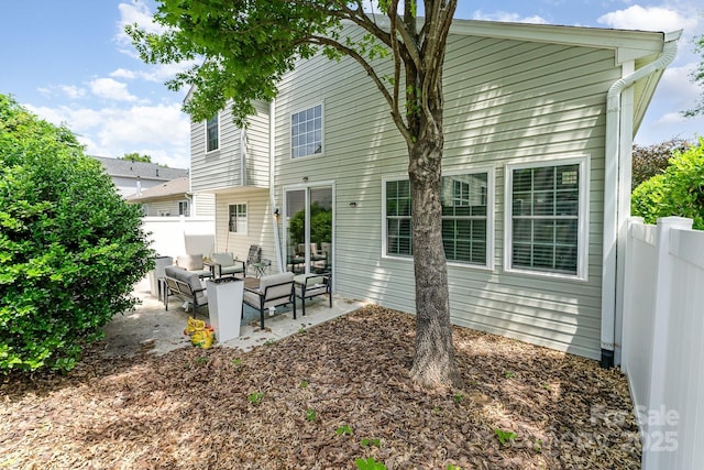 back of house featuring outdoor lounge area, a patio, and fence