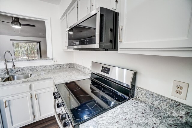 kitchen with stainless steel appliances, a sink, white cabinetry, and a ceiling fan