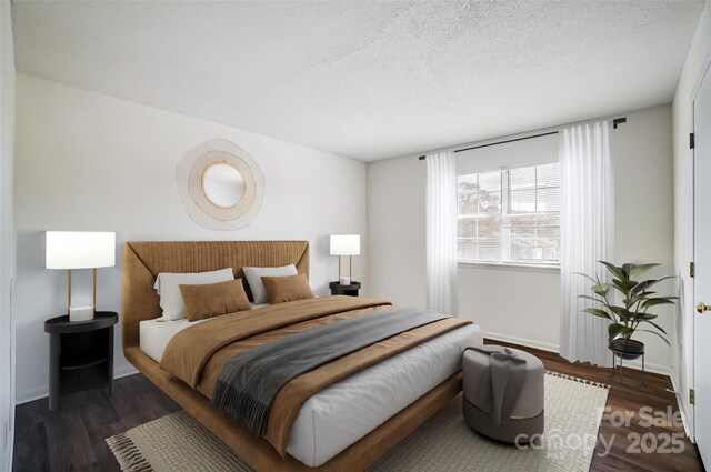 bedroom with wood finished floors, a textured ceiling, and baseboards