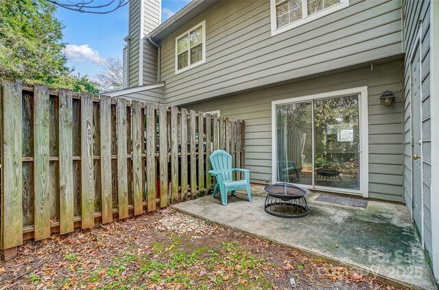 view of patio with an outdoor fire pit and fence