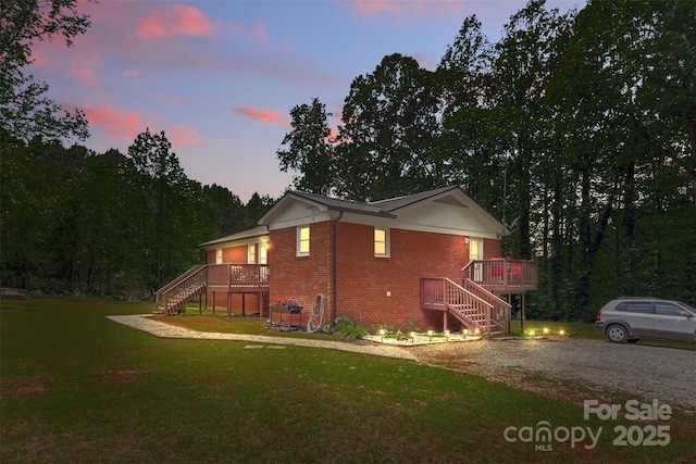 1792 Hoffman Rd, Gastonia, NC 28054 - property exterior at dusk featuring stairs, brick siding, a lawn, and a deck