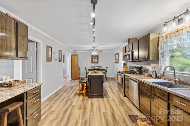 1792 Hoffman Rd, Gastonia, NC 28054 - kitchen featuring a sink, appliances with stainless steel finishes, light wood-style flooring, a kitchen breakfast bar, and crown molding