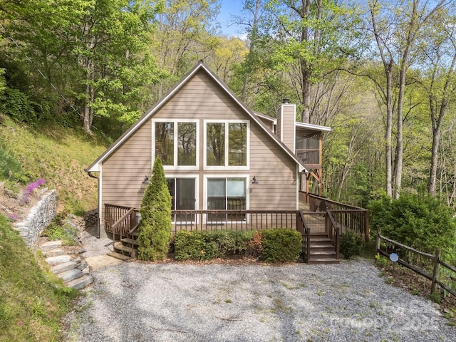 exterior space featuring stairway, a deck, and a chimney