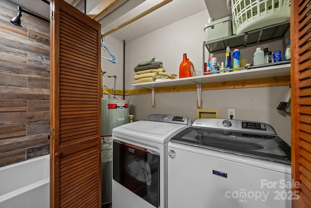 washroom with laundry area, wood walls, separate washer and dryer, and electric water heater