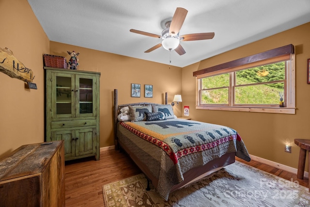 bedroom with baseboards, ceiling fan, and wood finished floors