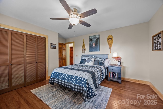 bedroom with a ceiling fan, baseboards, wood finished floors, and a closet