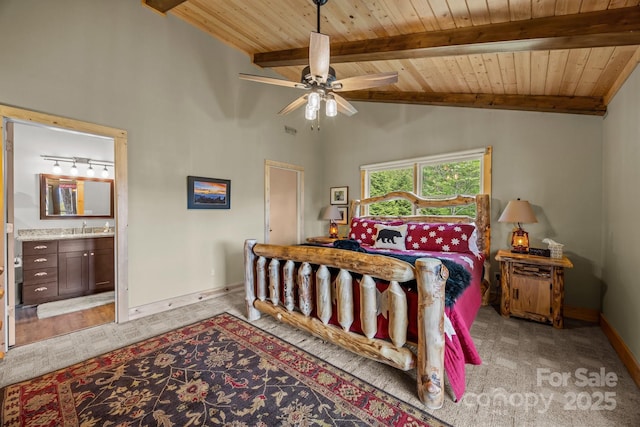 bedroom featuring carpet floors, beamed ceiling, baseboards, ensuite bathroom, and wood ceiling