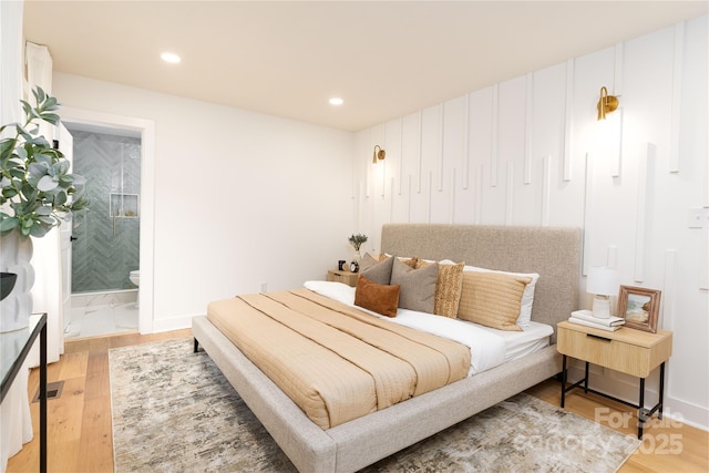 bedroom featuring ensuite bath, light wood-type flooring, and recessed lighting