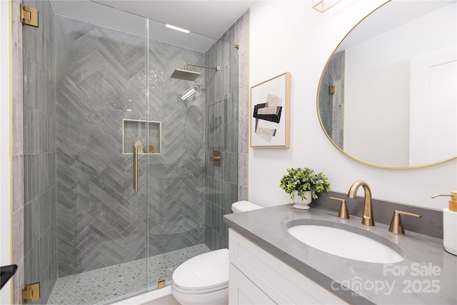 full bathroom with a stall shower, vanity, and toilet
