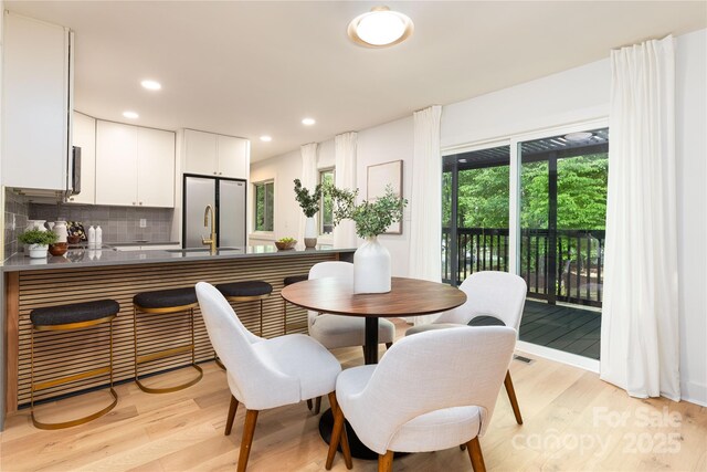 dining room with light wood-style floors and recessed lighting