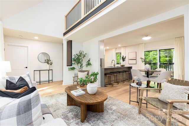 living room featuring light wood finished floors, baseboards, and recessed lighting