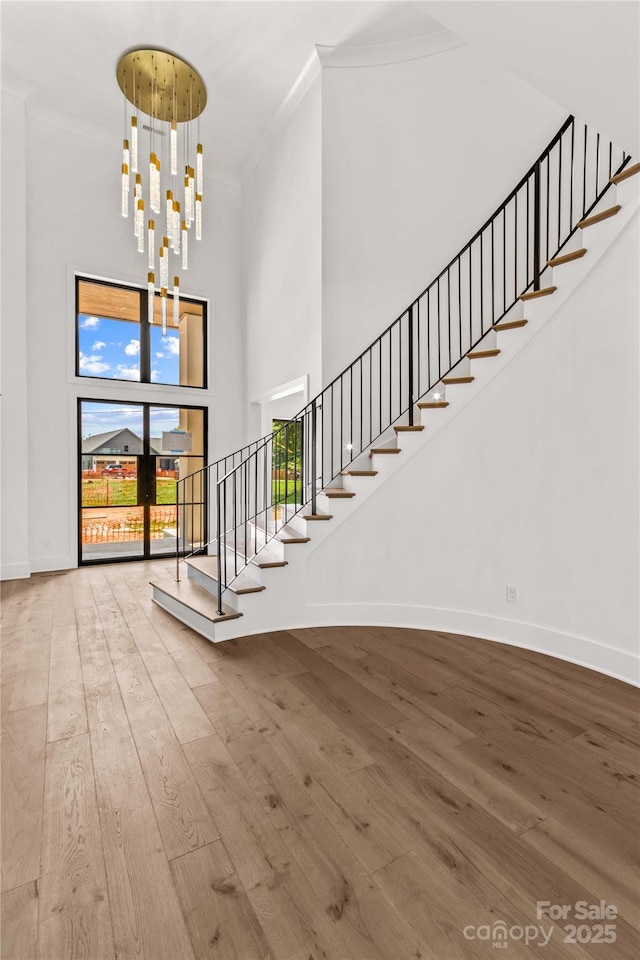 242 Shoreline Loop, Mooresville, NC 28117 - foyer featuring a high ceiling, crown molding, wood finished floors, stairway, and a chandelier
