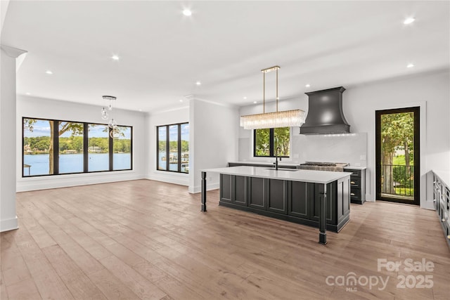 242 Shoreline Loop, Mooresville, NC 28117 - kitchen featuring custom exhaust hood, light countertops, dark cabinets, recessed lighting, and light wood-type flooring