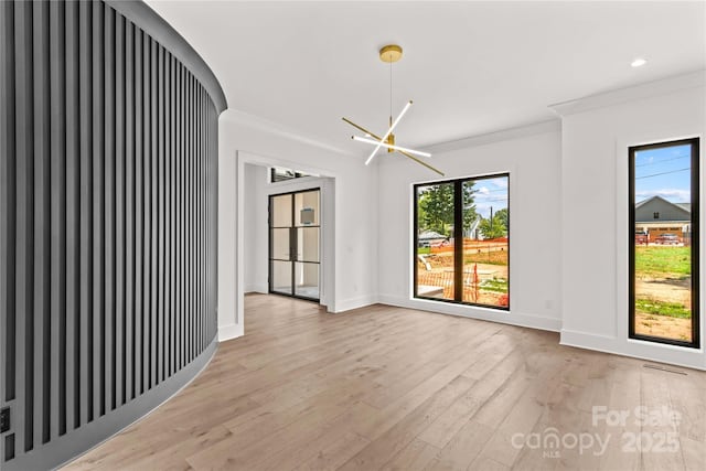 242 Shoreline Loop, Mooresville, NC 28117 - spare room featuring a chandelier, crown molding, and light wood finished floors