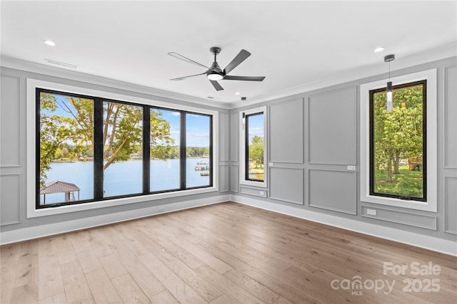 242 Shoreline Loop, Mooresville, NC 28117 - empty room with a decorative wall, healthy amount of natural light, a ceiling fan, crown molding, and wood finished floors