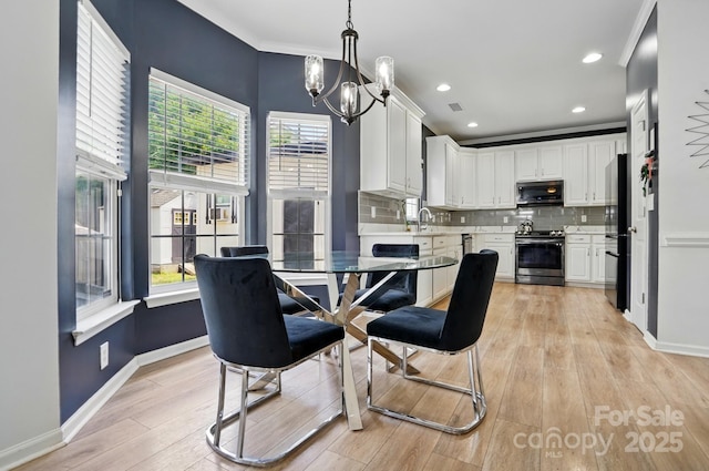 8833 Cavonnier Ln, Charlotte, NC 28216 - dining space with light wood finished floors, a chandelier, recessed lighting, and baseboards