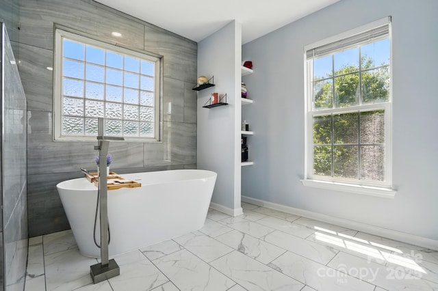 8833 Cavonnier Ln, Charlotte, NC 28216 - bathroom with marble finish flooring, healthy amount of natural light, a freestanding tub, and tile walls
