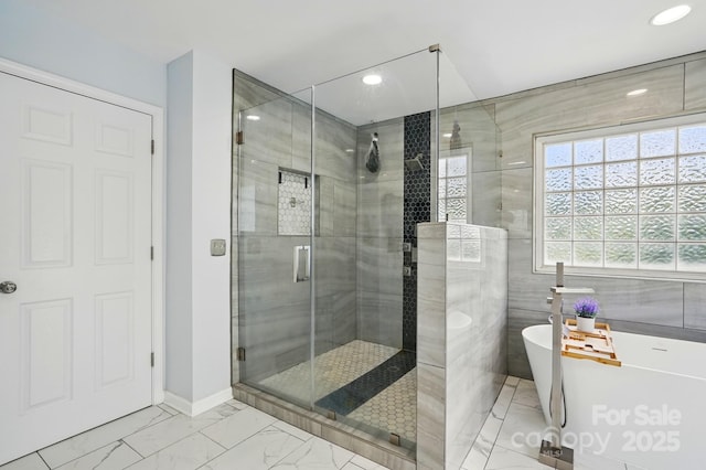 8833 Cavonnier Ln, Charlotte, NC 28216 - full bathroom with a shower stall, marble look tile flooring, a freestanding bath, recessed lighting, and tile walls