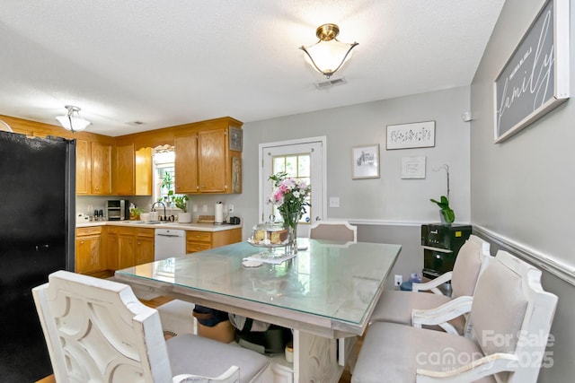 dining space featuring visible vents, a textured ceiling, and a wealth of natural light