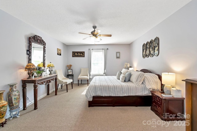carpeted bedroom with baseboards, a textured ceiling, ceiling fan, and multiple windows