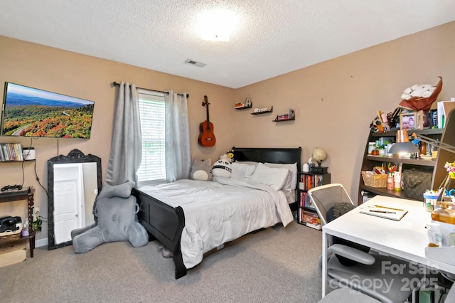 bedroom with visible vents, a textured ceiling, and carpet