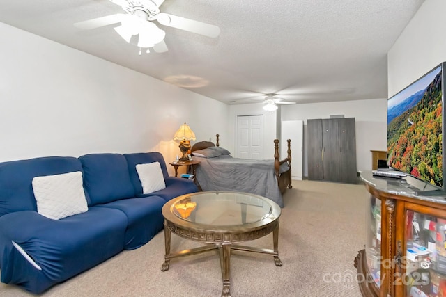 carpeted living area featuring a textured ceiling and ceiling fan