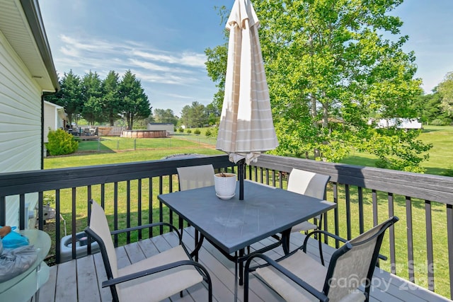 wooden deck featuring outdoor dining area and a yard