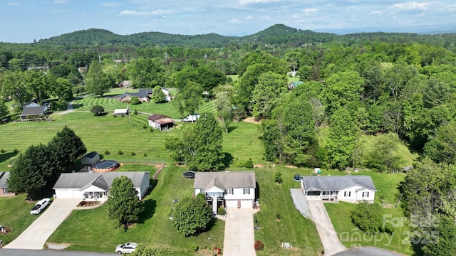aerial view featuring a wooded view and a mountain view