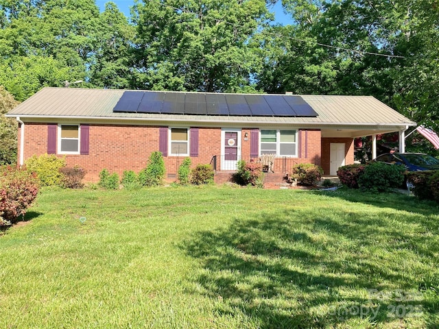 single story home featuring brick siding, a front lawn, and solar panels