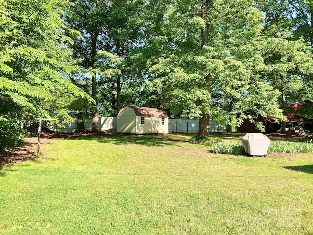 view of yard featuring an outbuilding, a shed, and a fenced backyard