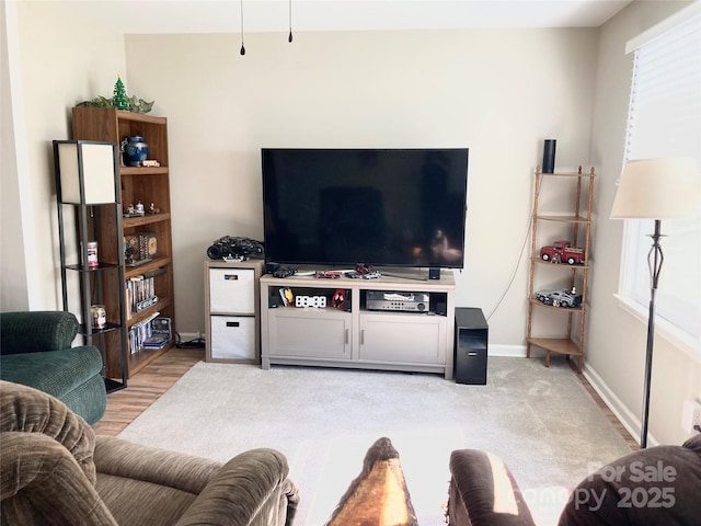 living room with baseboards, a wealth of natural light, and light wood-type flooring