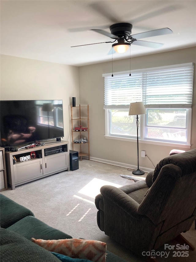 living area with a ceiling fan and light colored carpet