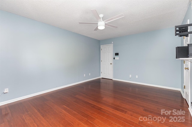 empty room featuring a ceiling fan, wood finished floors, baseboards, and a textured ceiling
