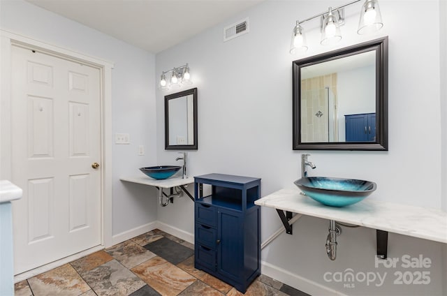 bathroom featuring stone tile floors and baseboards