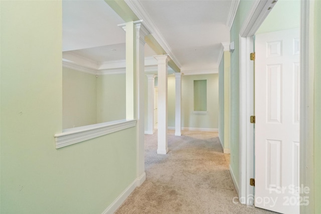 hall featuring crown molding, carpet flooring, baseboards, and ornate columns