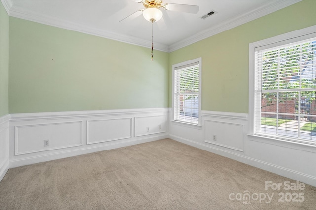 empty room with light colored carpet, crown molding, and visible vents